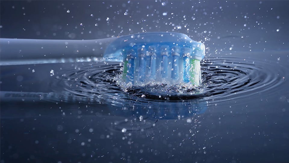 a toothbrush that is turned on while creating a splash in the water