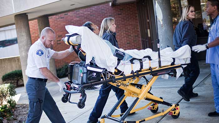 Healthcare workers bring patient into the hospital on a stretcher