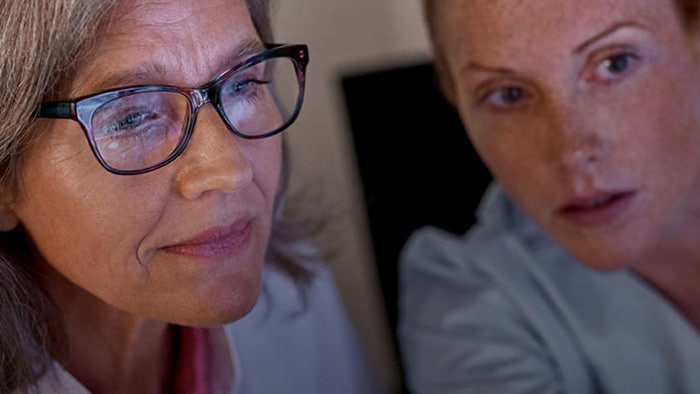 Two people with screen light reflecting on their face