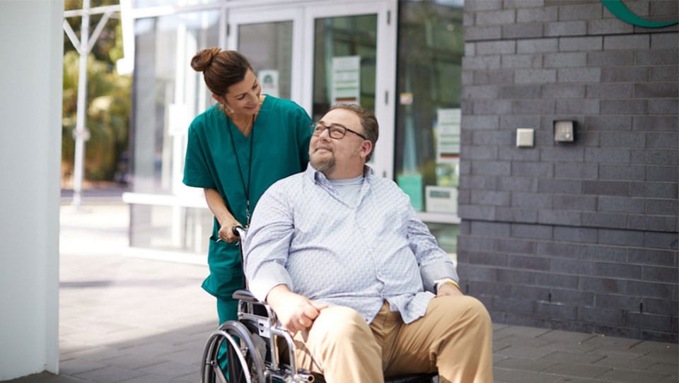 Healthcare profession carries patient with wheelchair