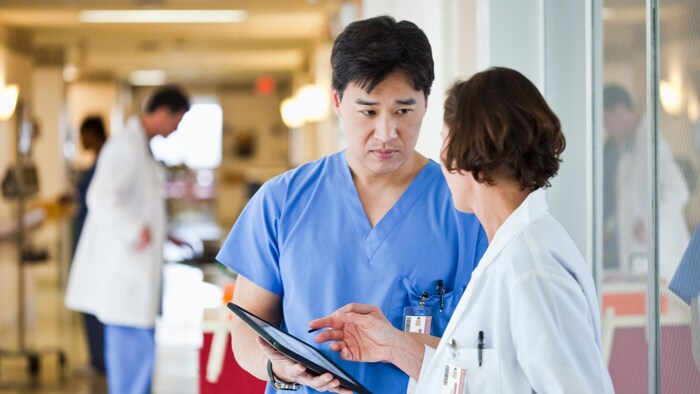 Two clinicians discussing over a tablet about improving the acoustical environment 