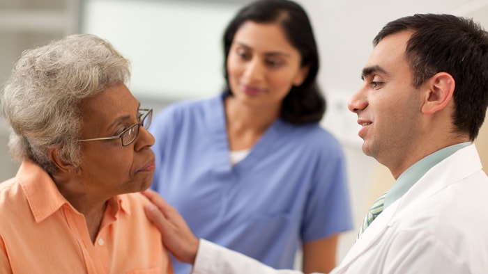 Senior patient meets with the doctor and the doctor has a reassuring look