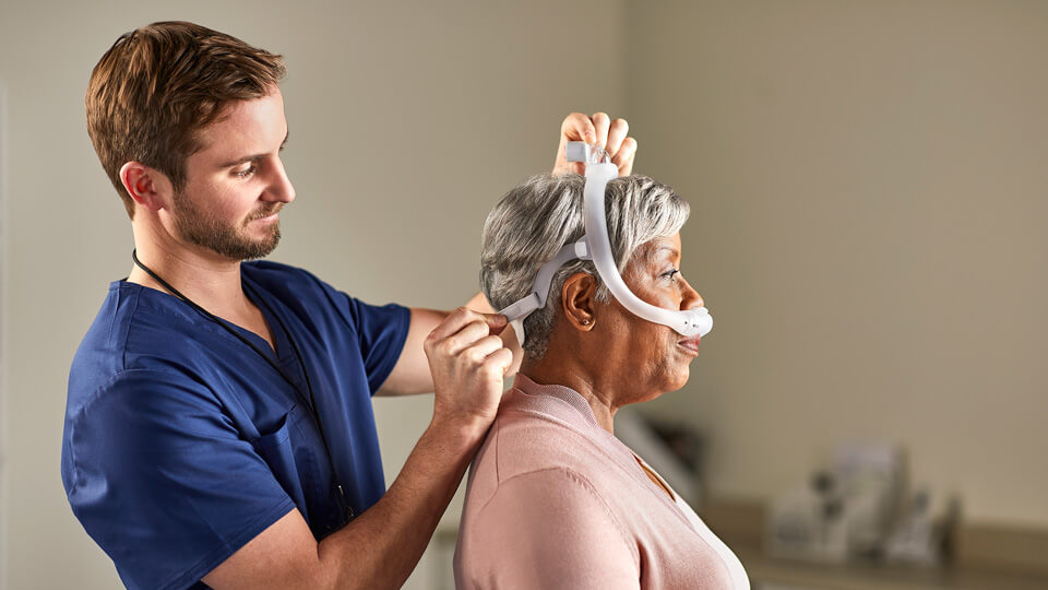 Clinician fitting patient for mask