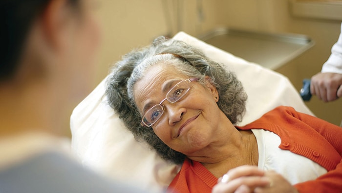 An old patient lying on bed and smiling
