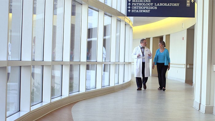 Patient and doctor walking down hall