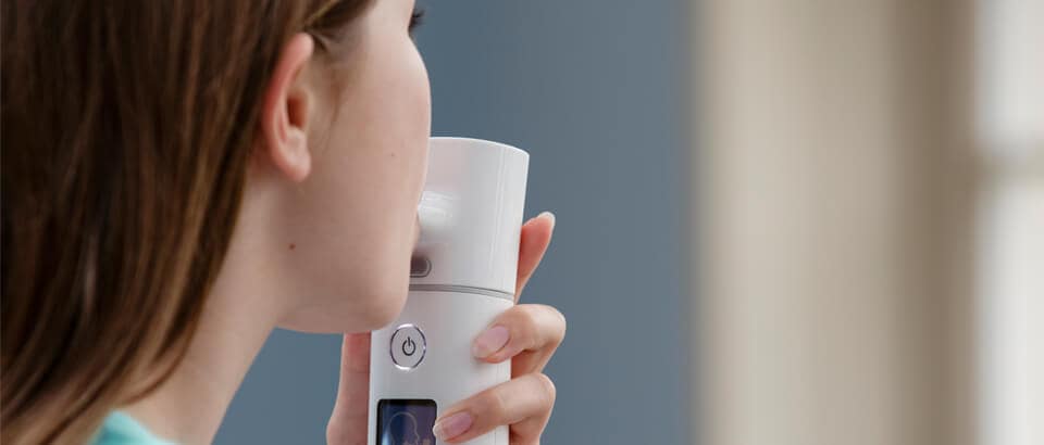 Woman using i-neb advanced nebulizer device