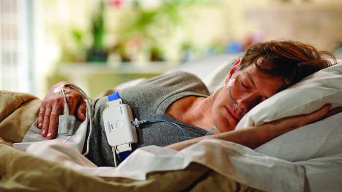 Photograph of man in bed asleep on his side using a Philips sleep test