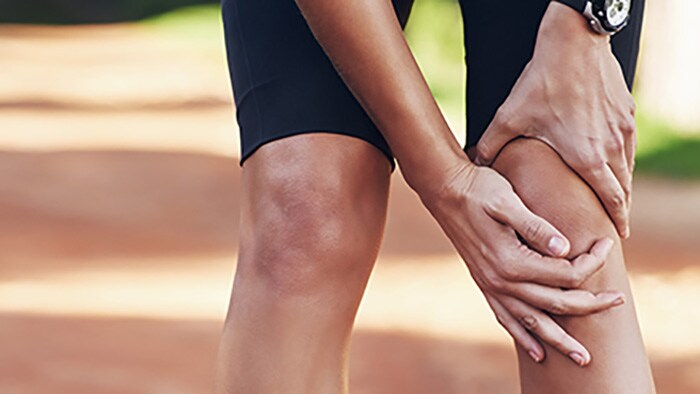 Man holding knee due to fibromyalgia