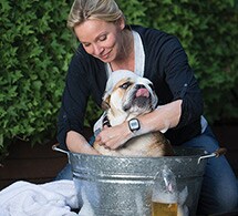 Woman bathing dog while wearing actiwatch
