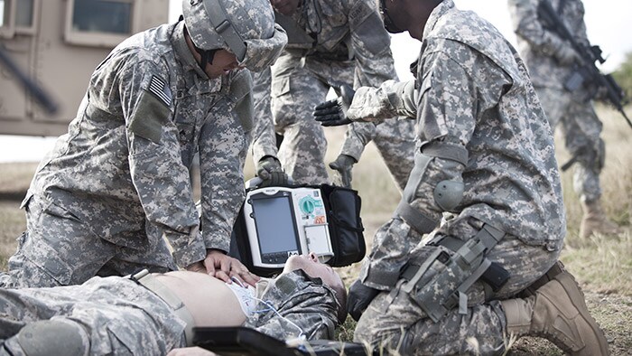 A soldier giving chest compressions.