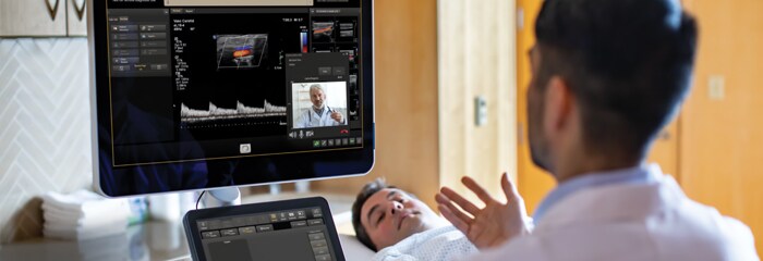 Doctor monitoring screen while talking with patient