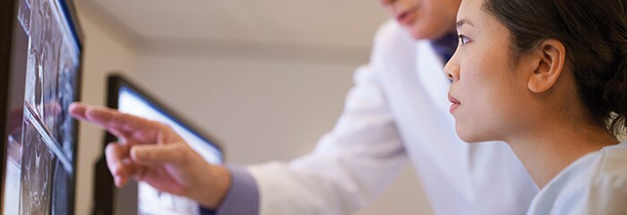 Medical professional pointing to screen while other watches