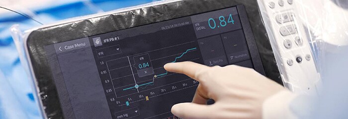 Doctor pointing towards graph on screen