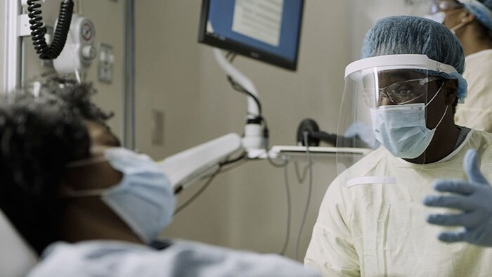 Healthcare worker speaking to patient in bed