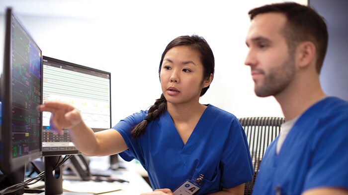 Two healthcare professionals talking and looking at screen