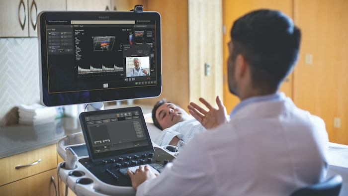 Doctor looking at dual screens in patient’s room