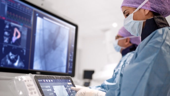 Cardiologists pushing buttons on second screen