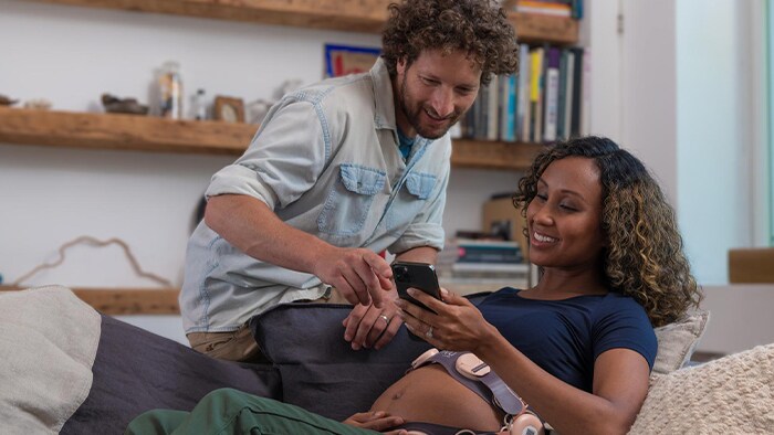 Man and pregnant partner looking at phone together