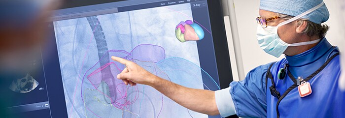 Medical professionals pointing to large screen
