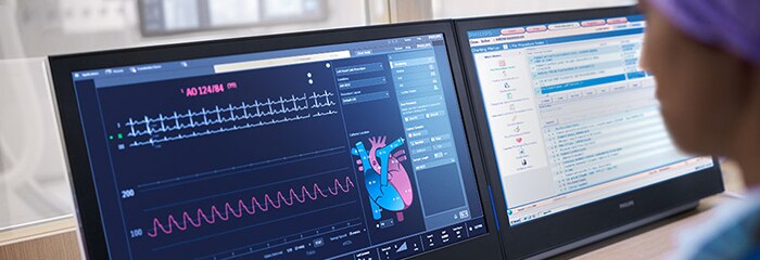 Medical professional closely watching two screens