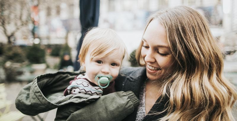 Mom holding baby smiling