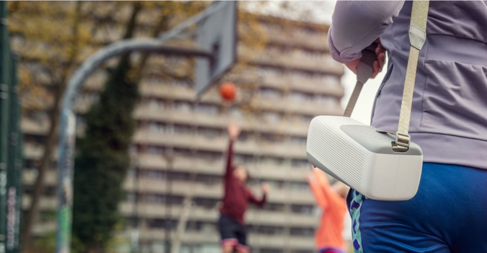 Woman carrying her Philips bluetooth speaker by its strap