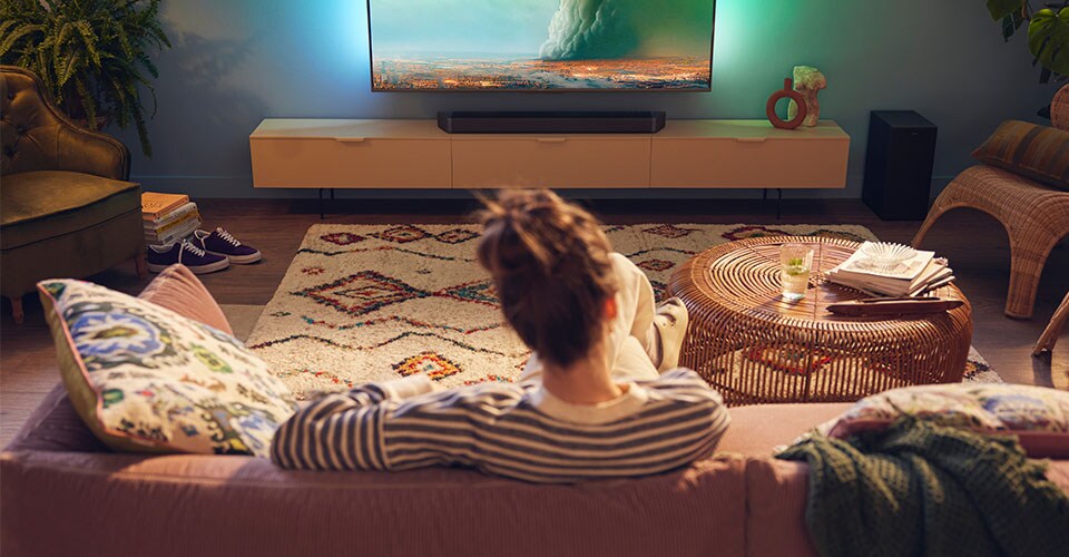Woman enjoying her Philips SoundBar in living room