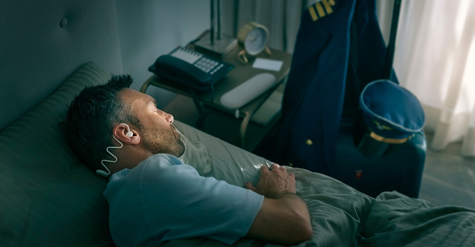 A man sleeping comfortably on his side with Philips Sleep Headphones.