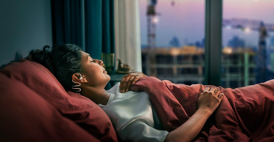 Couple sleeping, with the woman wearing Philips Sleep Headphones