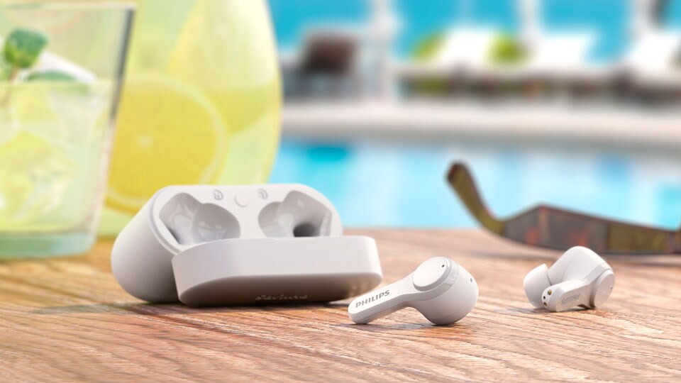T3217 wireless noise canceling headphones in front of cocktail glasses