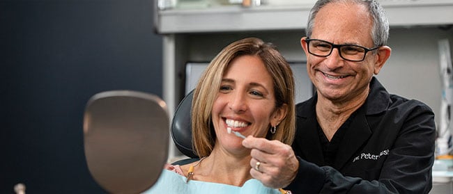 Dental professional showing a patient her teeth whitening results
