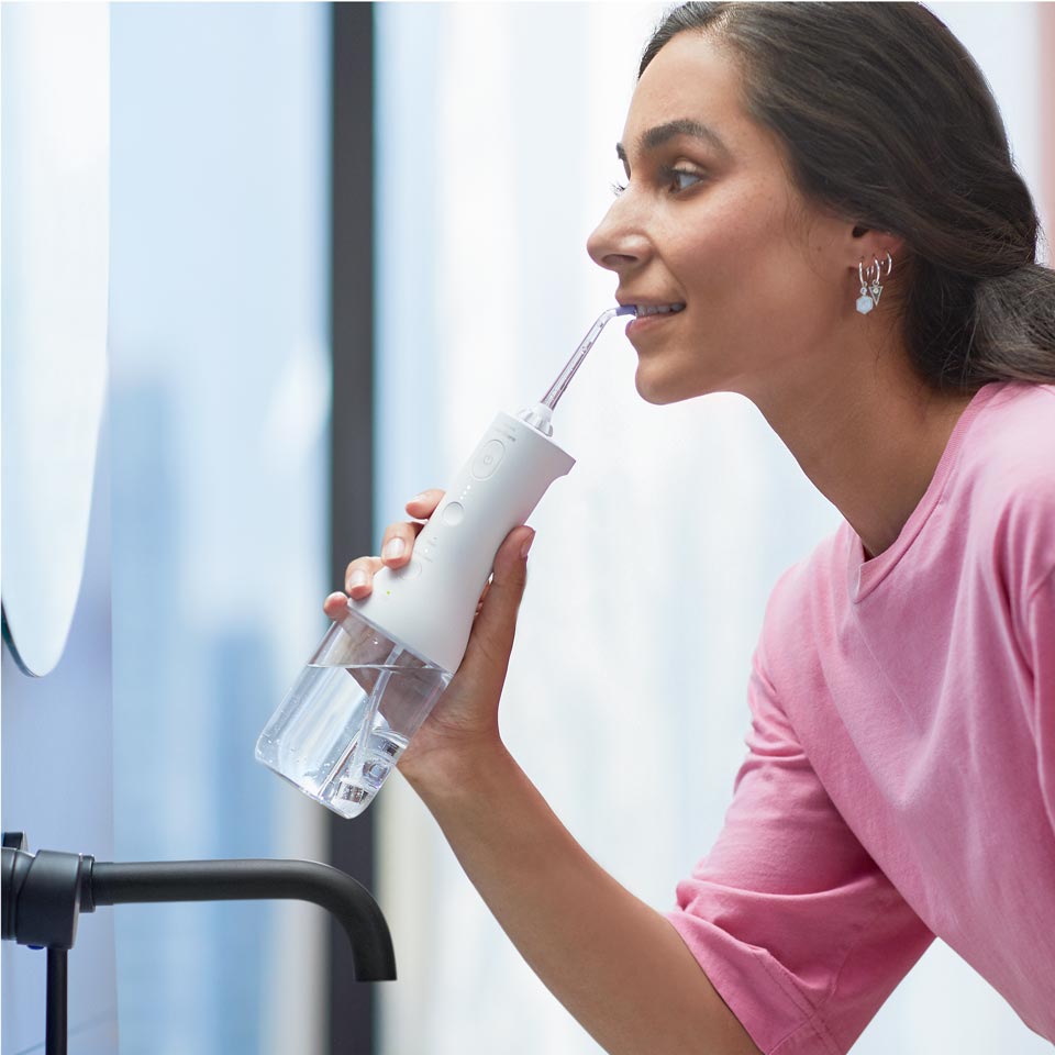 Woman using a Cordless Power Flosser