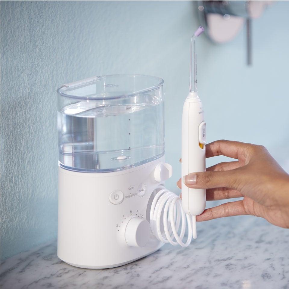 Hand reaching to grab a Power Flosser handle