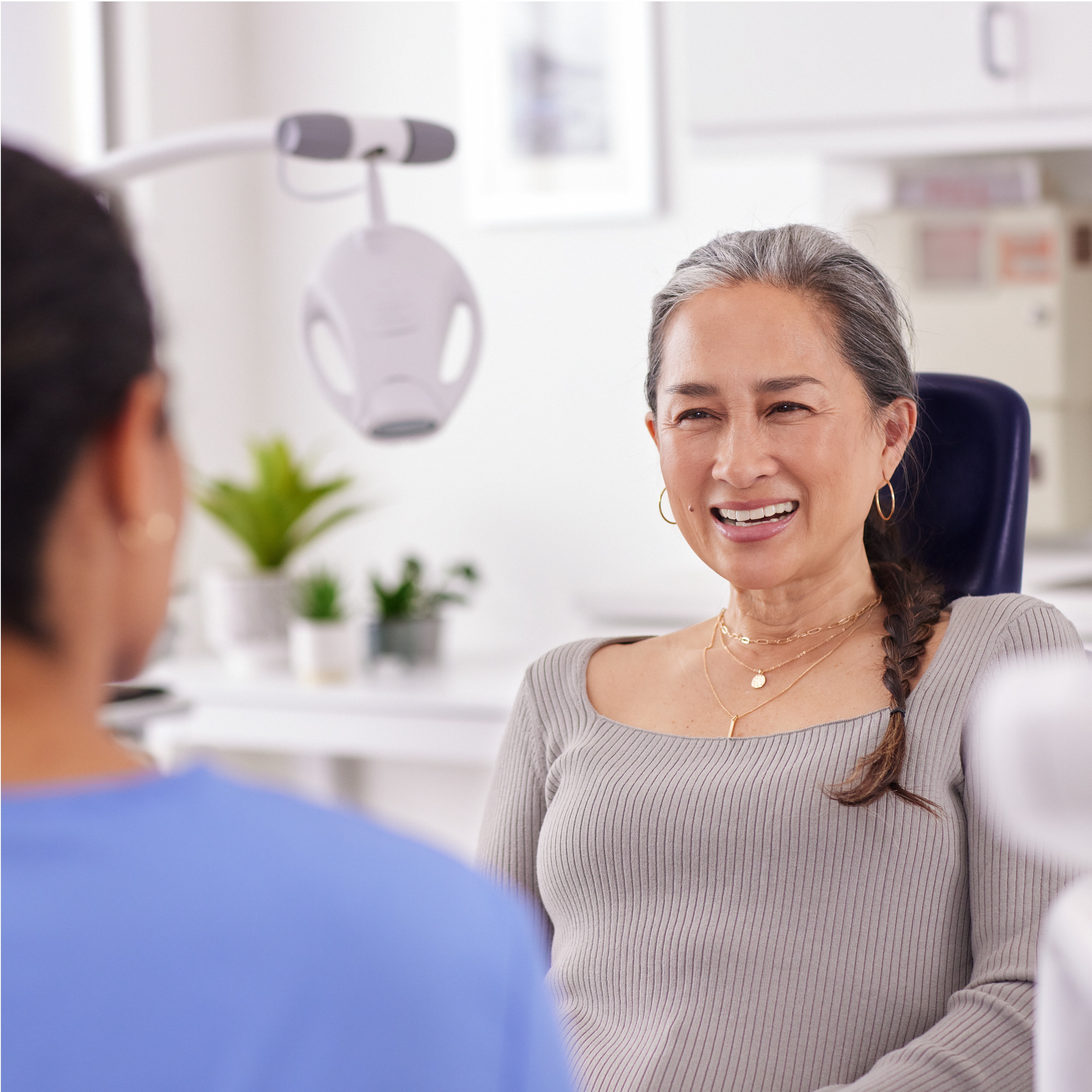 A patient talking to a dental professional with a Philips Zoom! WhiteSpeed lamp in the background