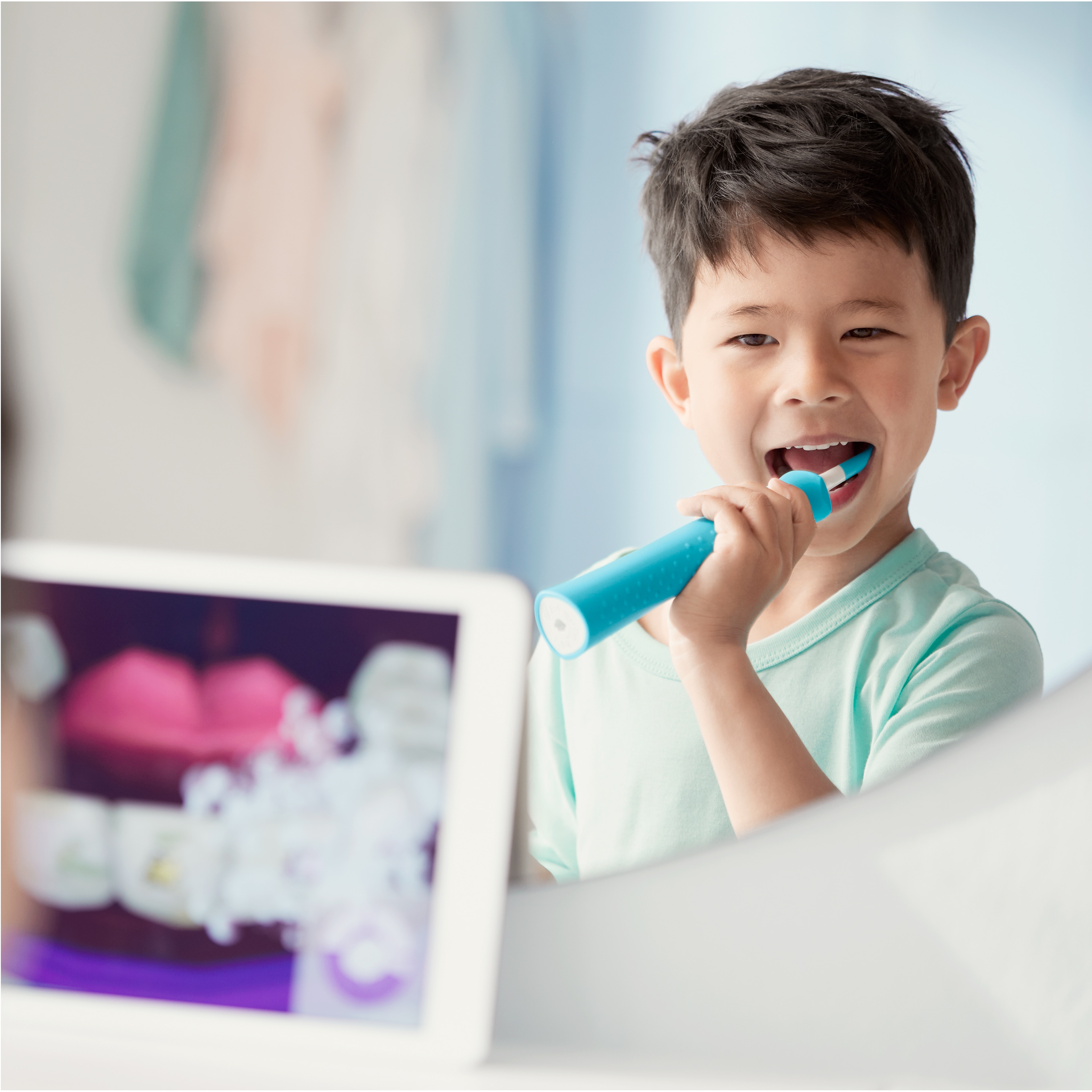 Boy using a Sonicare For Kids power toothbrush while watching the Sonicare For Kids app