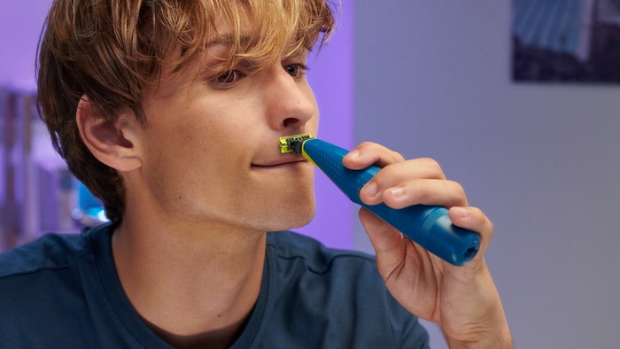 Young person shaving moustache