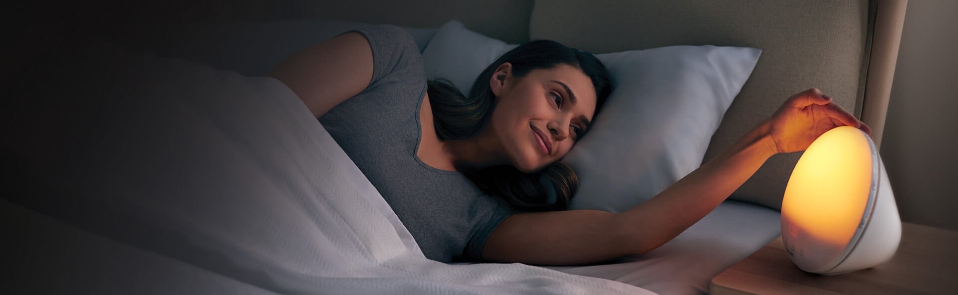 Woman waking up using a Philips sleep and wake up light